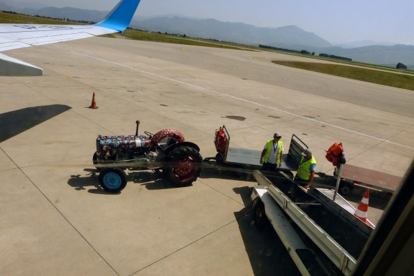 Zdjęcie z Czarnogóry - po walizki pod samolot podjeżdża kolorowy traktor! 😊 